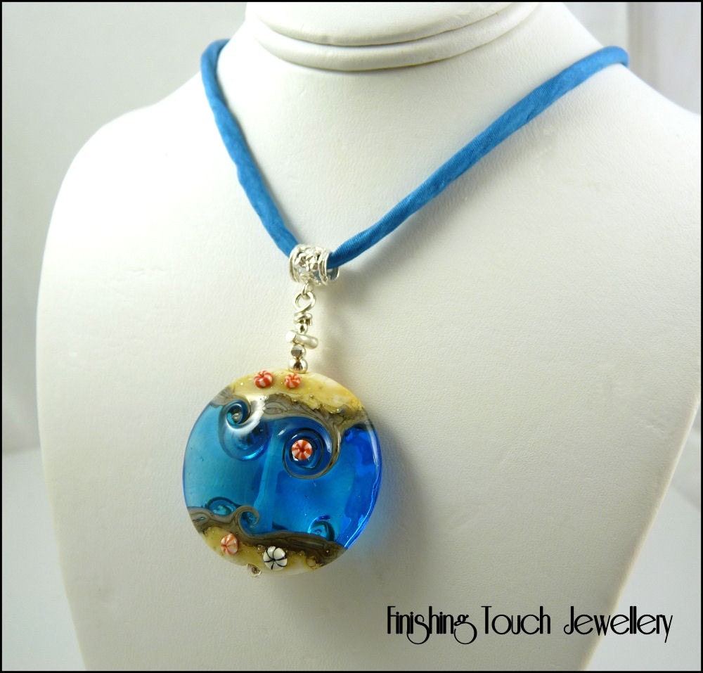 This is a gorgeous lampwork pendant made by me from transparent aquamarine with ends of silvered ivory.