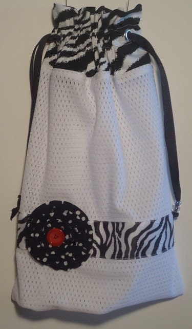 White mesh pointe/ballet shoe bag.  Zebra print topper with zebra print wide ribbon and white poka dots on black rosette flower.  Black drawstrings with beads for easy closer.