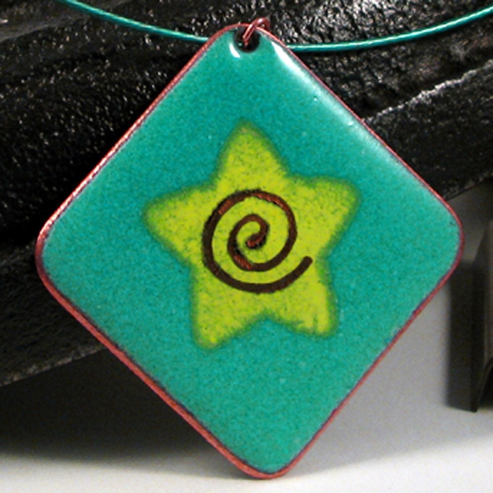 A stunning turquoise and lime green enamel on copper pendant with a star motif and a polished copper edge.