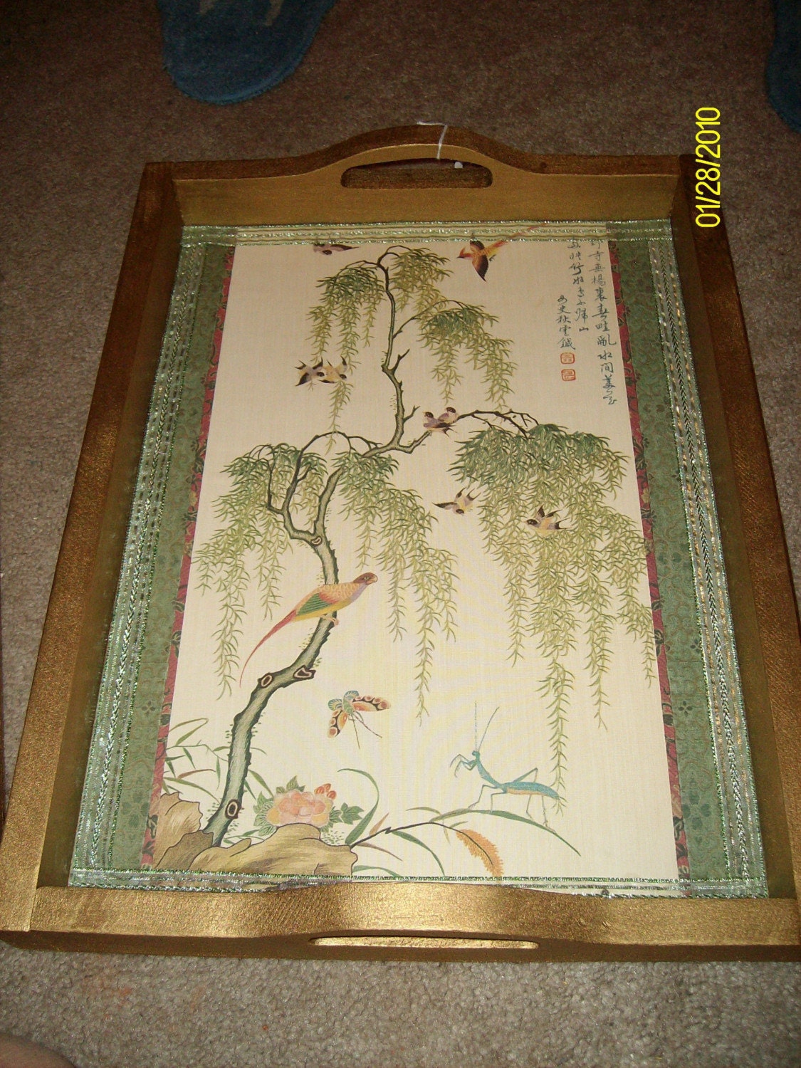 This is a beautiful wooden tray that has been painted gold and has an oriental design wallpaper on the bottom. I bought this tray at a yard sale and painted 