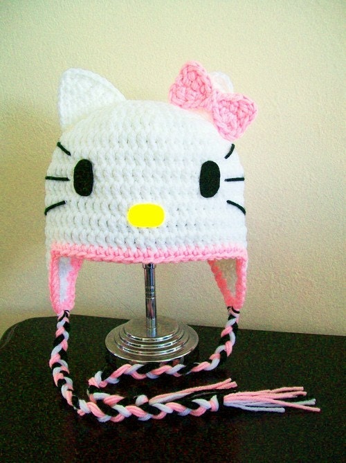 Hand crocheted Hello Kitty Hat with Earflaps, Braids, and Pink Bow. All size available from newborn to adult sizes. Please specify hat size during purchase.