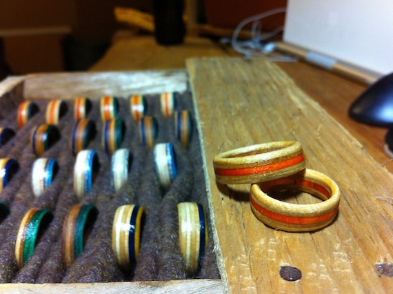Rings with an orange stripe made from skateboard decks