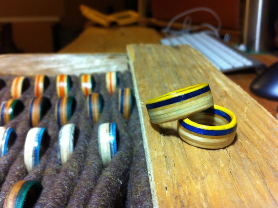Rings with a blue & yellow stripe hand cut from skateboard decks